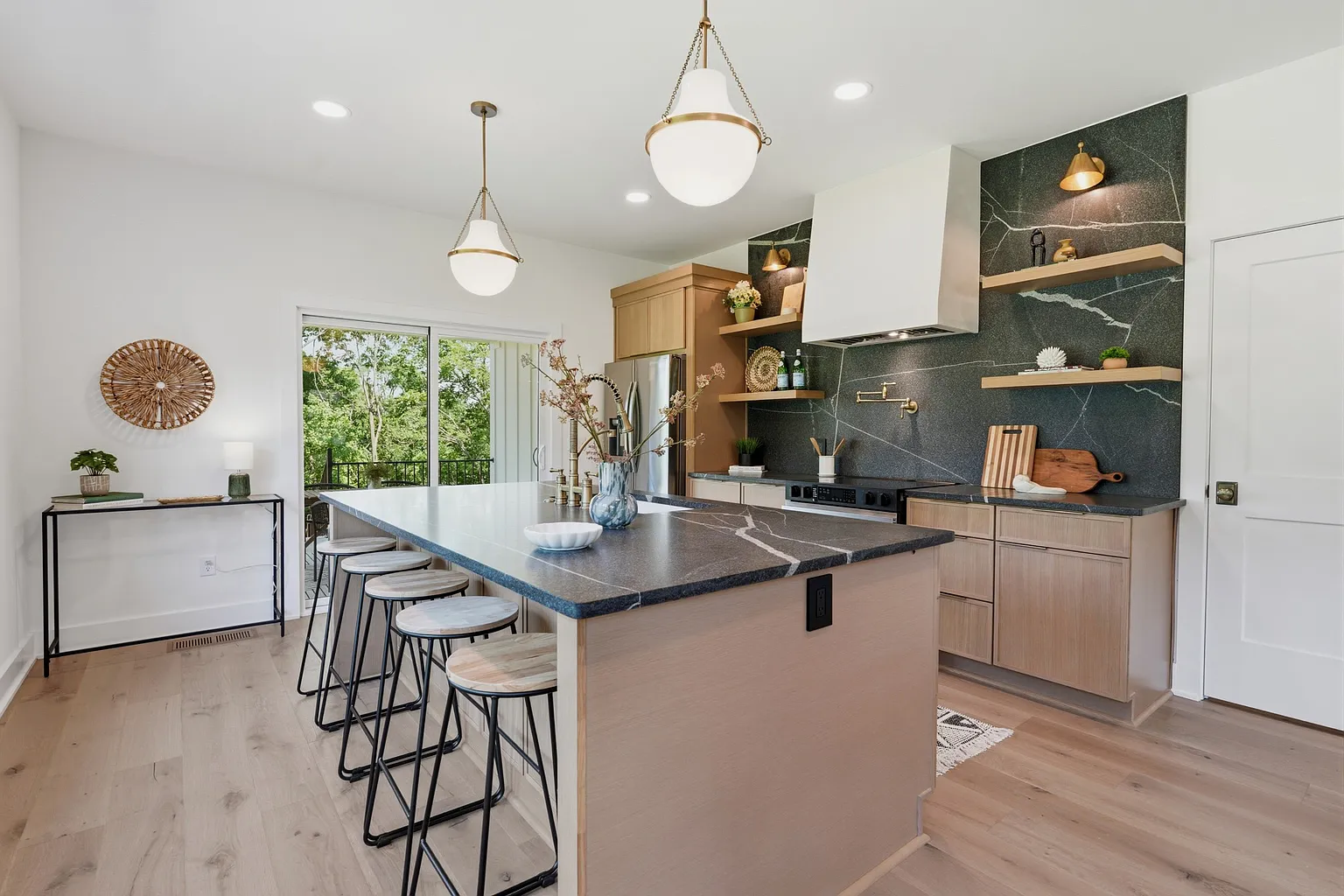 Kitchen with white oak cabinetry, brass fixtures, and exposed brick